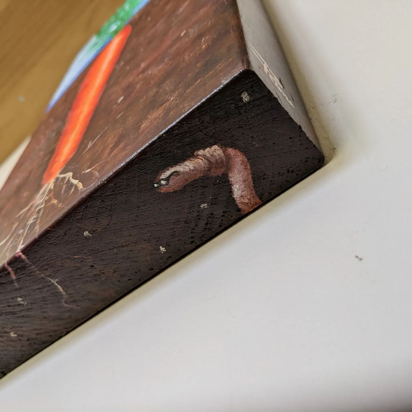 Detail of worm painted on bottom edge of canvas